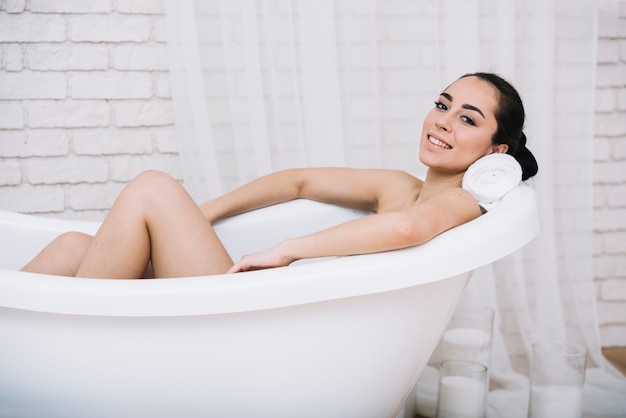 Frau, die ein entspannendes Bad in einem Badekurort nimmt