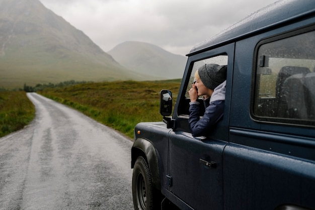 Kostenloses Foto frau, die ein foto aus dem autofenster macht