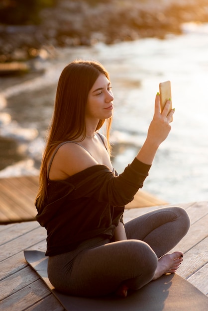 Frau, die ein Foto des Meeres macht