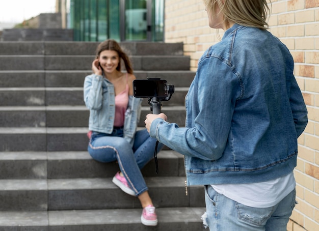 Frau, die ein Foto ihres Freundes mit einem Smartphone macht