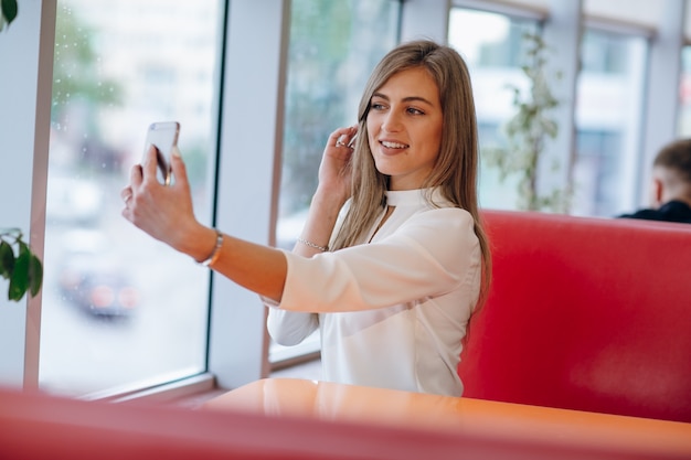 Frau, die ein Foto mit ihrem Handy zu sich selbst