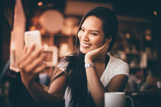 Frau, die ein Foto mit ihrem Handy