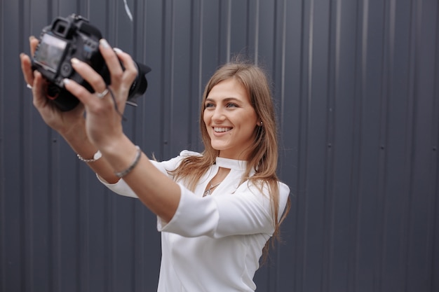 Frau, die ein Foto von sich selbst mit einer Spiegelreflexkamera