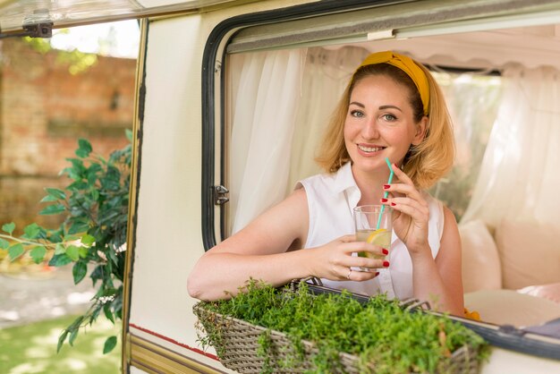 Frau, die ein Glas Limonade in einer Karawane hält