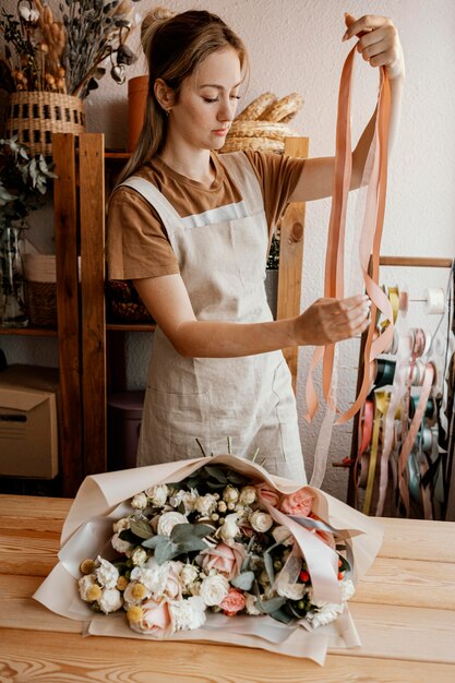 Frau, die ein hübsches Blumenarrangement macht