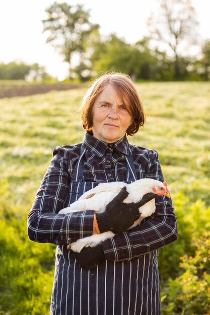 Frau, die ein Huhn hält