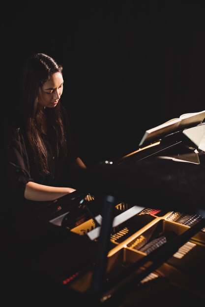 Frau, die ein Klavier im Musikstudio spielt