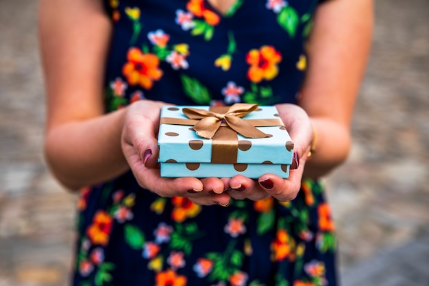 Frau, die ein kleines Feiergeschenk zeigt