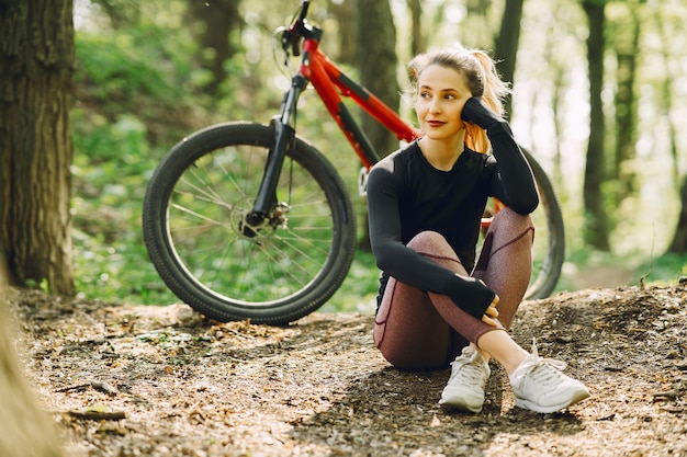 Frau, die ein Mountainbike im Wald reitet