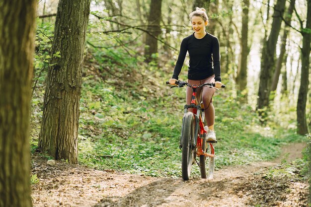 Frau, die ein Mountainbike im Wald reitet