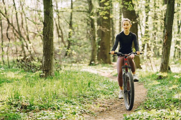 Frau, die ein Mountainbike im Wald reitet