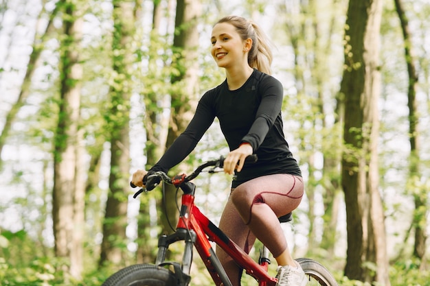 Frau, die ein Mountainbike im Wald reitet