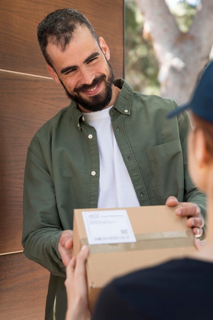 Frau, die ein Paket für einen Mann liefert