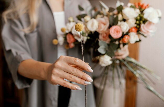 Frau, die ein schönes Blumenarrangement macht