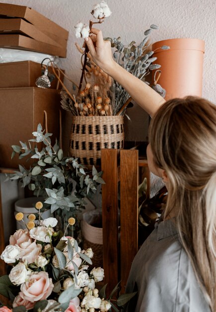 Frau, die ein schönes Blumenarrangement macht