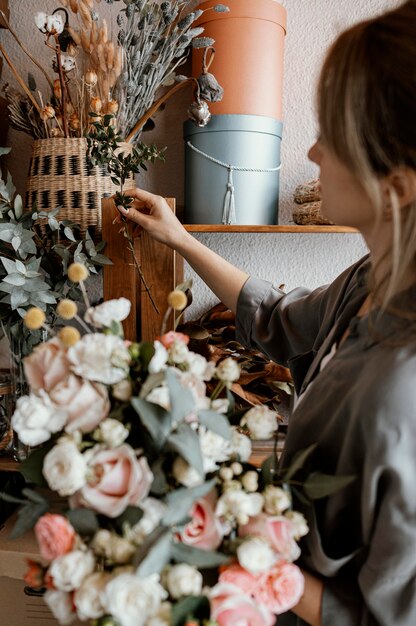 Frau, die ein schönes Blumenarrangement macht