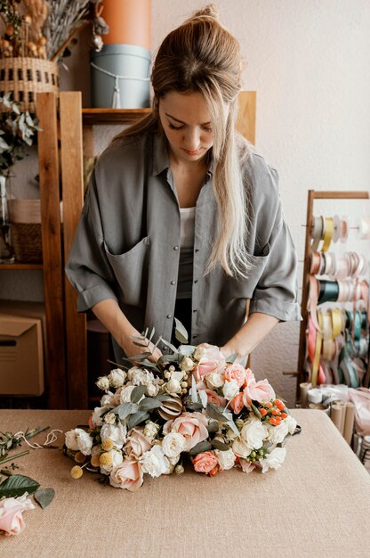 Frau, die ein schönes Blumenarrangement macht