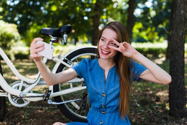 Frau, die ein selfie nahe bei ihrem Fahrrad nimmt