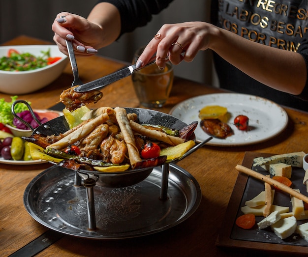 Kostenloses Foto frau, die ein stück fleisch von der beutelplatte nimmt