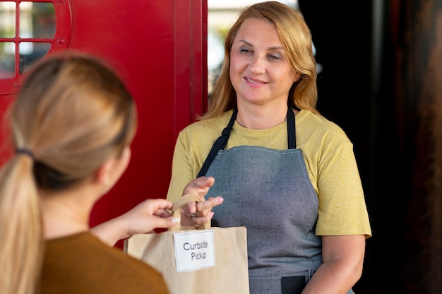 Frau, die eine Bestellung bei einer Abholung am Straßenrand im Freien aufgibt