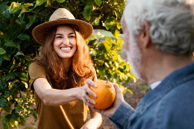 Frau, die eine frische orange mit ihrem vater hält