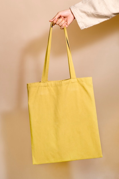 Frau, die eine gelbe Einkaufstasche in der Hand hält