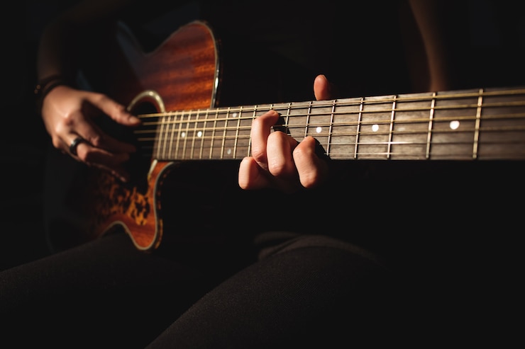 Kostenlose Foto frau, die eine gitarre in der musikschule spielt