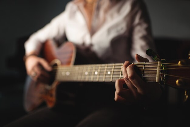 Frau, die eine Gitarre in der Musikschule spielt