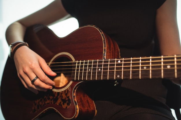 Frau, die eine Gitarre in der Musikschule spielt