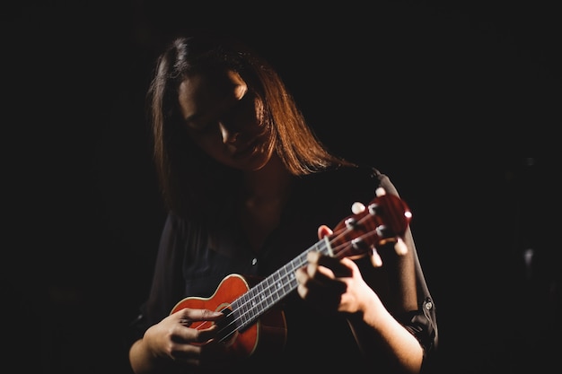 Frau, die eine Gitarre in der Musikschule spielt