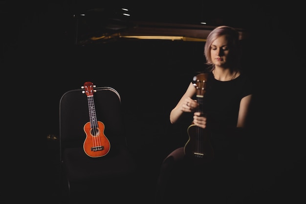 Frau, die eine Gitarre in der Musikschule spielt