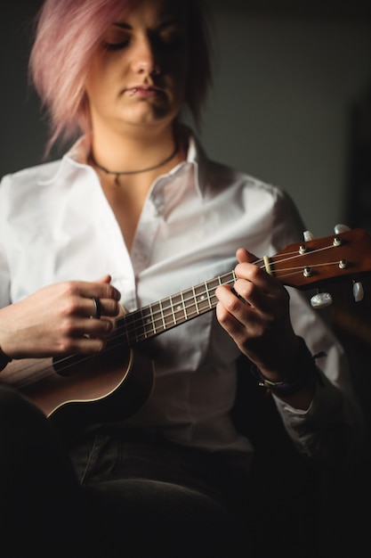 Kostenloses Foto frau, die eine gitarre spielt