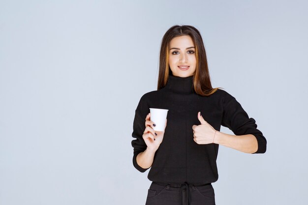 Frau, die eine Kaffeetasse hält und den Geschmack genießt.