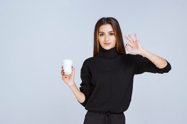 Frau, die eine Kaffeetasse hält und den Geschmack genießt.