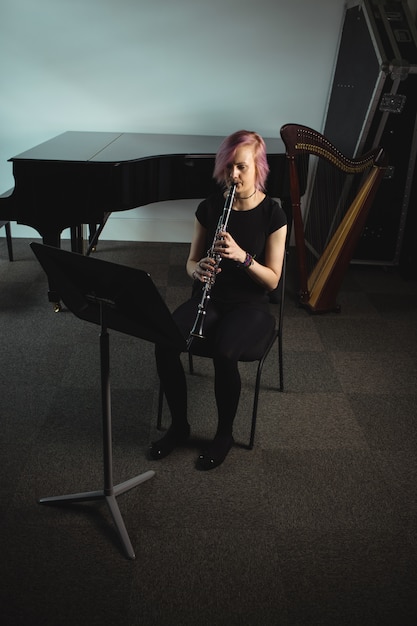 Kostenloses Foto frau, die eine klarinette in der musikschule spielt