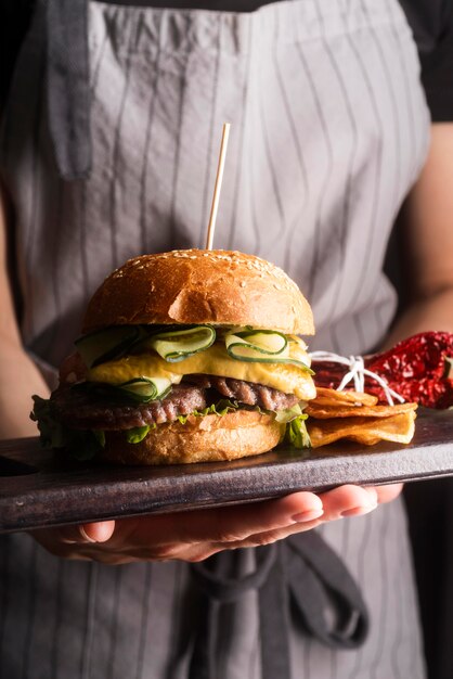 Frau, die eine leckere Mahlzeit mit Hamburger hält