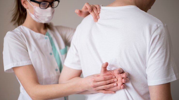 Kostenlose Foto frau, die eine maske trägt und einen patienten überprüft