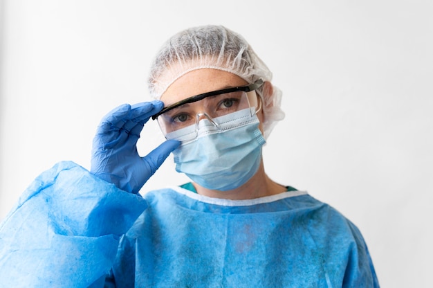 Frau, die eine medizinische Schutzausrüstung mit chirurgischer Maske trägt
