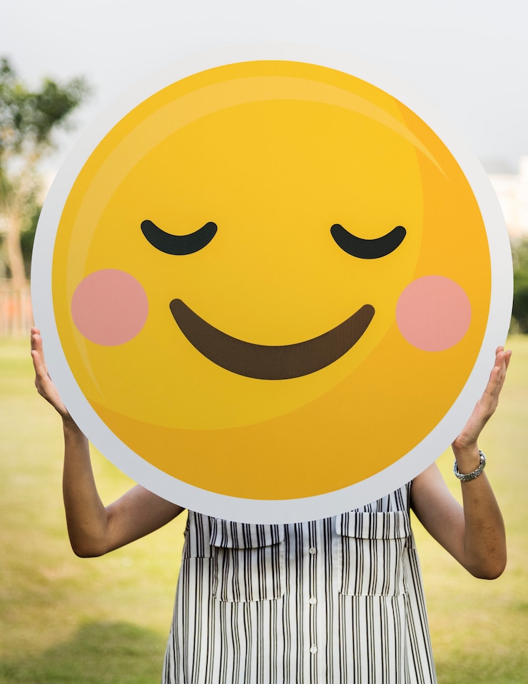 Kostenlose Foto frau, die eine smileygesichtsikone hält
