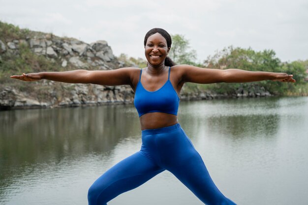 Frau, die eine Yoga-Pose draußen lehrt