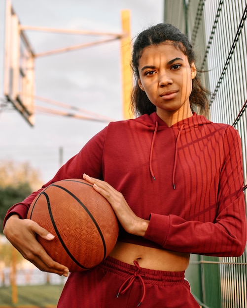Frau, die einen Basketball draußen hält