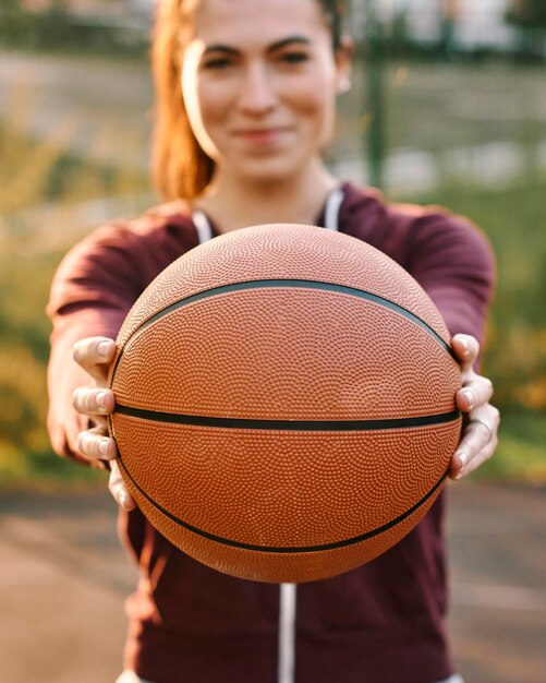 Frau, die einen Basketball vor ihr hält