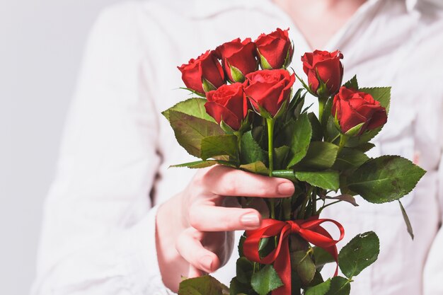 Frau, die einen Blumenstrauß von Rosen