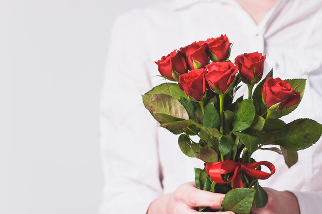 Frau, die einen Blumenstrauß von Rosen