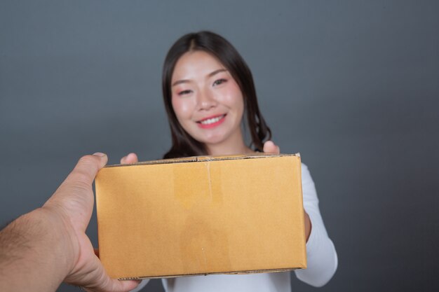 Frau, die einen braunen Briefkasten hält Machte Gesten mit Gebärdensprache.