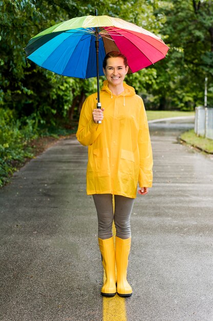 Frau, die einen bunten Regenschirm hält