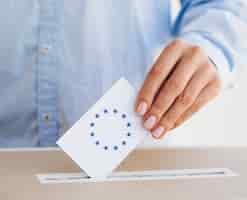 Kostenloses Foto frau, die einen europäischen stimmzettel in kasten einsetzt