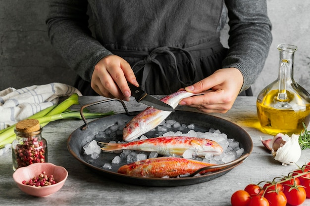 Frau, die einen Fisch zum Kochen vorbereitet