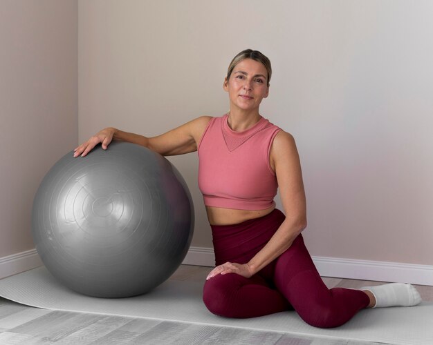 Frau, die einen Fitnessball für ihre Übungen verwendet