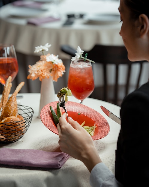 Frau, die einen grünen salat mit avacado im restaurant isst